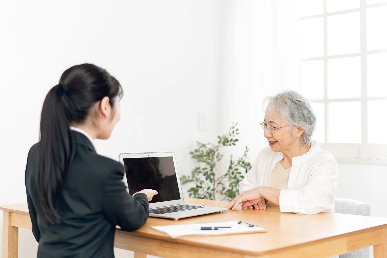 女性スタッフと向かい合って、話をするご高齢の女性