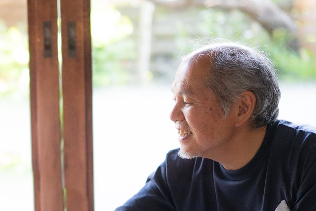 縁側で、穏やかに外を眺めるご高齢の男性（横顔）
