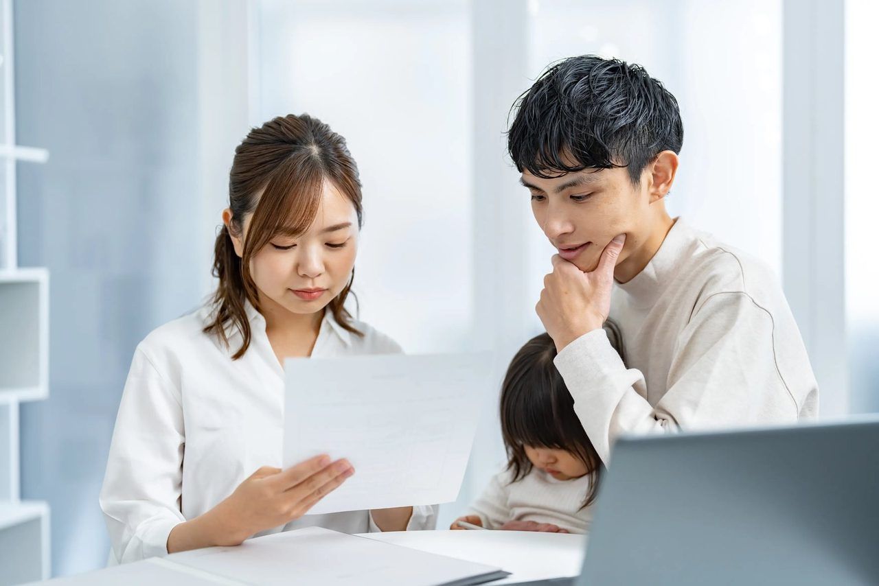 若いご夫婦と小さな子どもが、一緒に書類を見ているイ場面