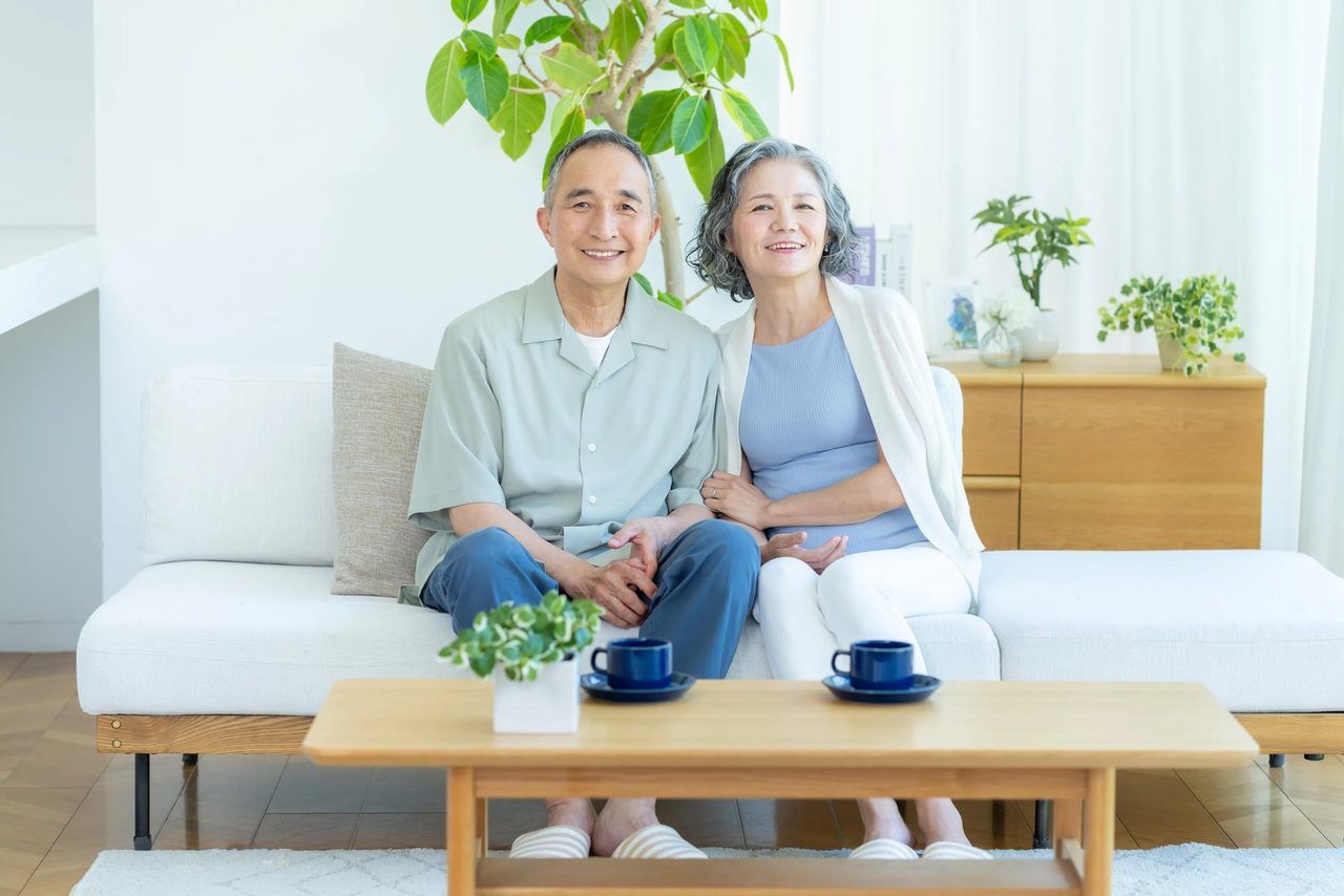 ソファに並んで座り、穏やかにほほえむご高齢のご夫婦