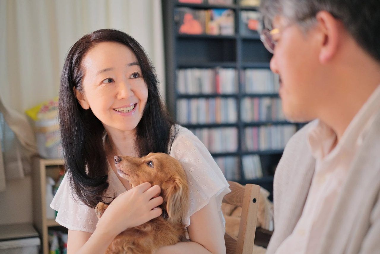 愛犬を抱く女性と、ご高齢の男性