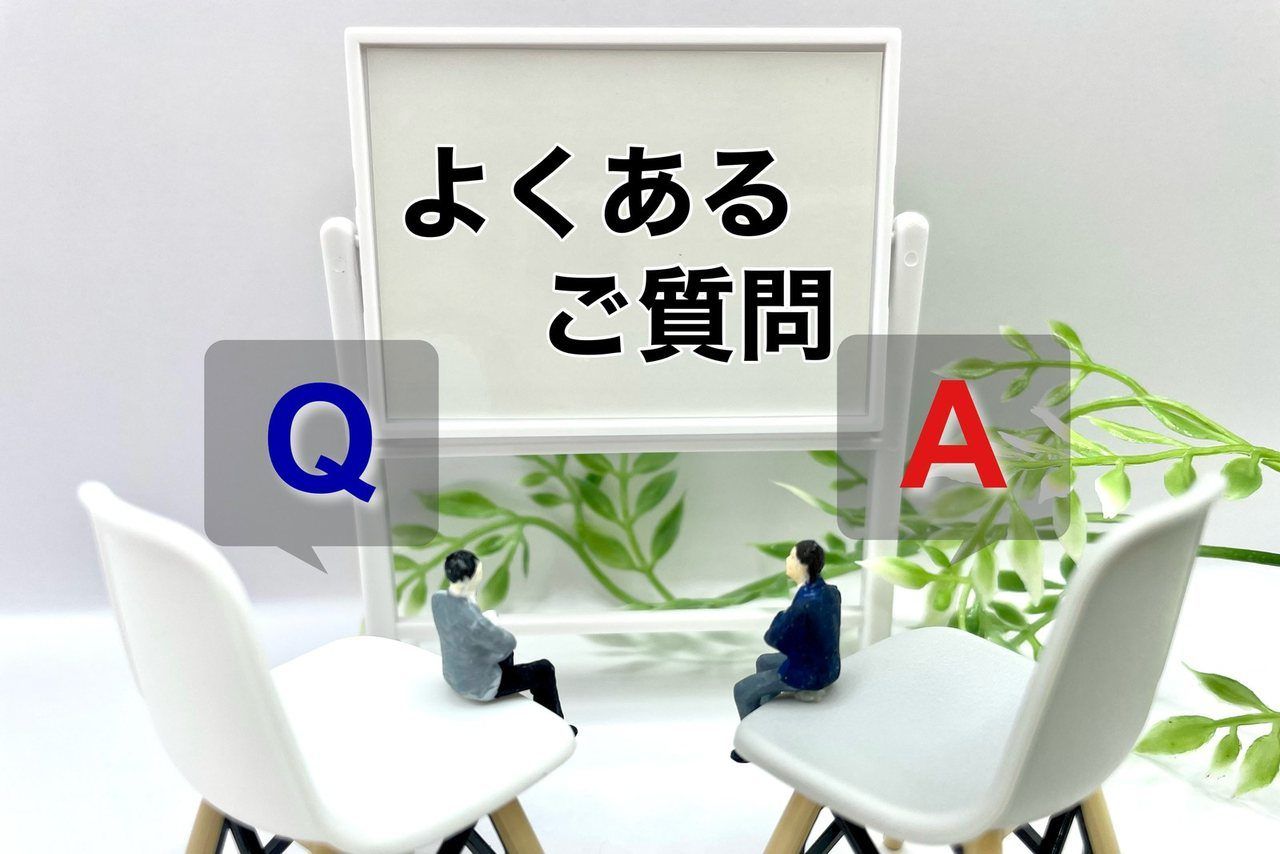 「よくある質問」のボードと、椅子に座る二つの人形