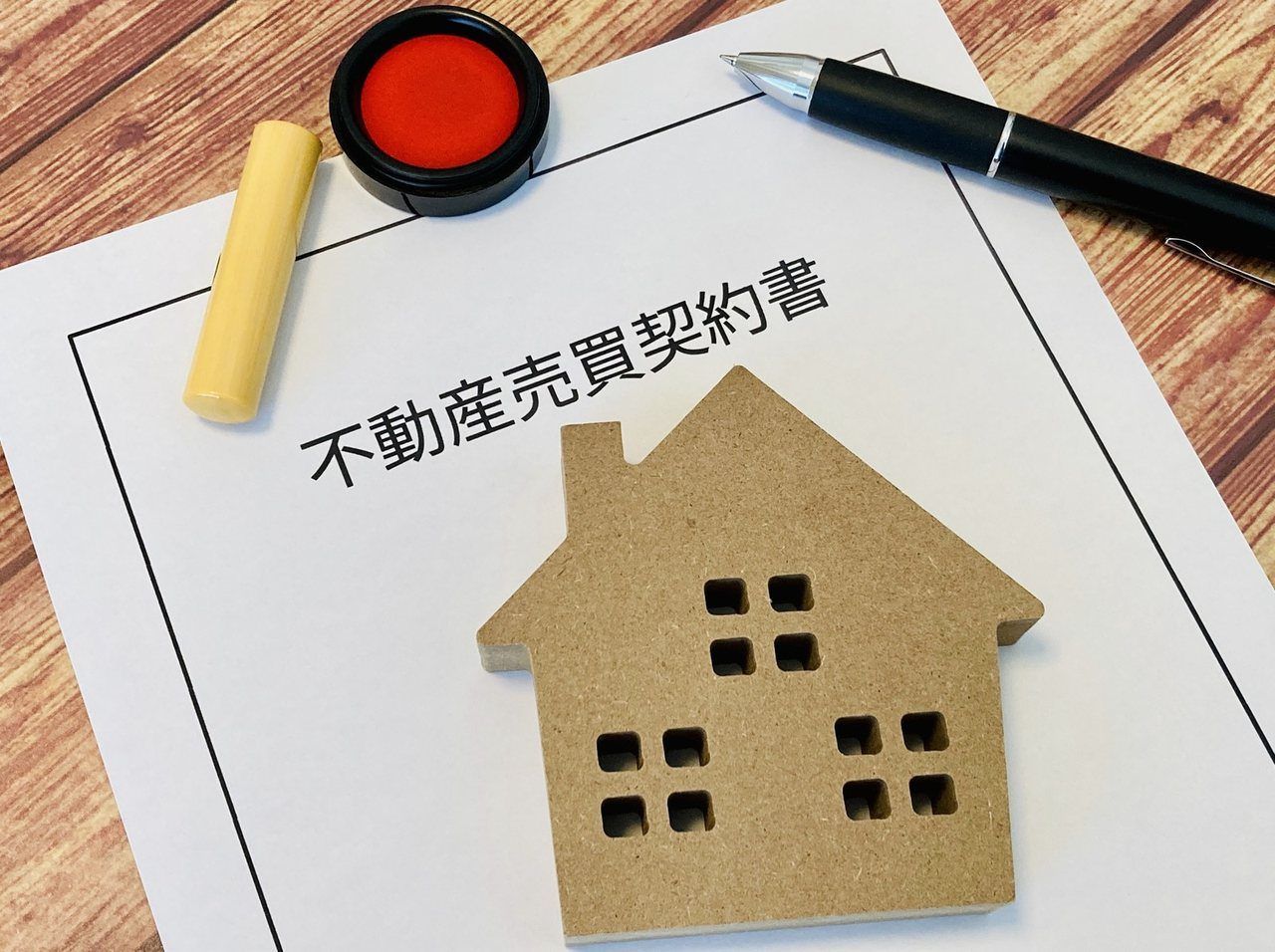 不動産売買契約書と印鑑、家の置物