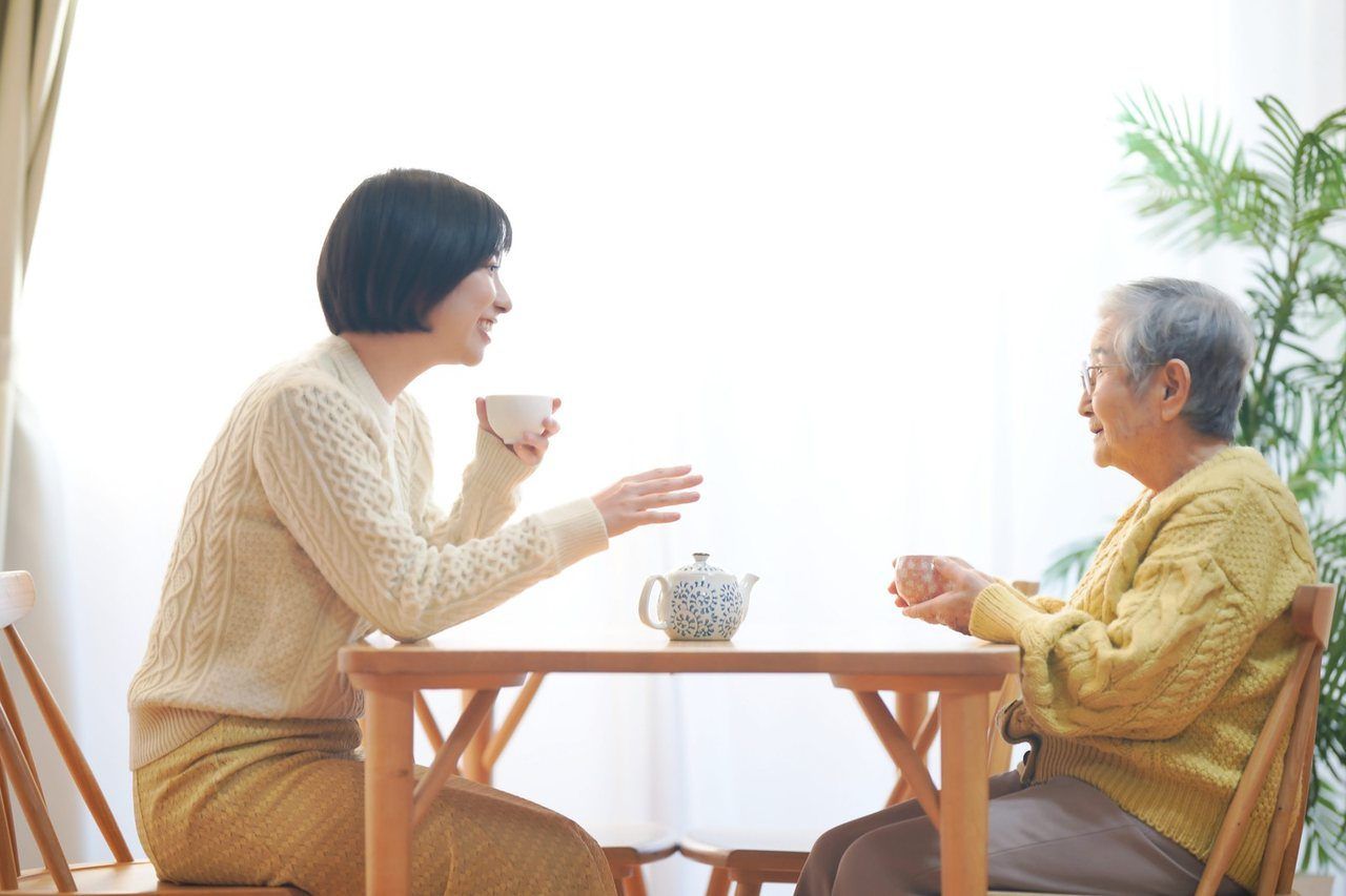 お茶を飲みながら、向かい合って話す二人の女性